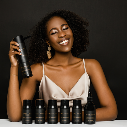 Model smiling with Luxia Artiss Keratin Thickening Fibers, the Precision Control Applicator and Set &amp; Seal Spray